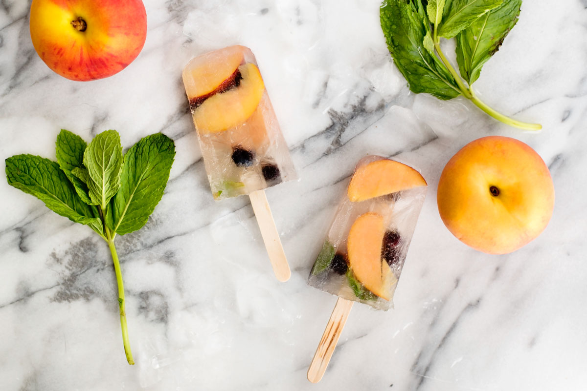 Summer is the best time for popsicles! Try these boozy sangria popsicles that have peaches, berries and mint